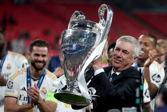 epa11384858 Real Madrid head coach Carlo Ancelotti lifts the trophy after the team won the UEFA Champions League final match of Borussia Dortmund against Real Madrid, in London, Britain, 01 June 2024. ...