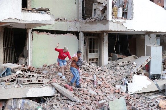 epa13063478 Residents walk through the rubble of damaged apartment buildings following the twin 7.2 and 7.5-magnitude earthquakes that struck the country, in Catia la Mar, Venezuela, 25 June 2026. At  ...