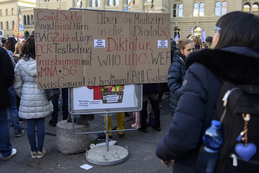 Plakat fotografiert vor das Bundeshaus, waehrend einer Demo gegen die Massnahmen im Zusammenhang mit dem Coronavirus, am Samstag, 22. Januar 2022, auf dem Bundesplatz, in Bern. (KEYSTONE/Anthony Anex)