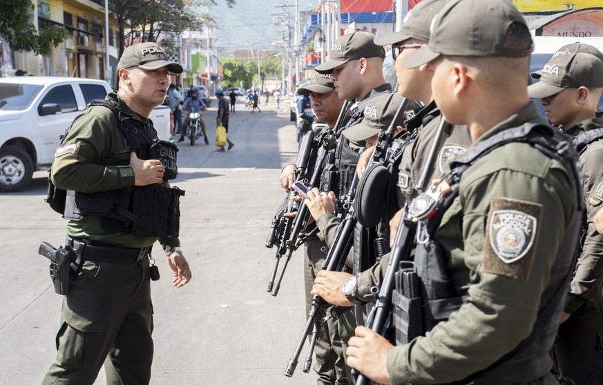 epa13258629 Colombian police officers guard a street following the violence unleashed by the illegal paramilitary group Autodefensas Conquistadoras de la Sierra Nevada (ACSN) in Santa Marta, Colombia, ...
