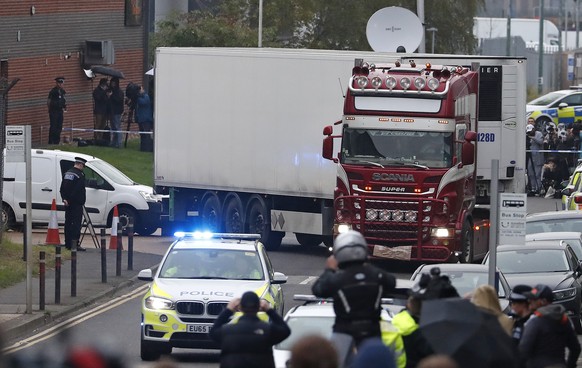 FILE - In this Wednesday Oct. 23, 2019 file photo, police escort the truck, that was found to contain a large number of dead bodies, as they move it from an industrial estate in Thurrock, south Englan ...