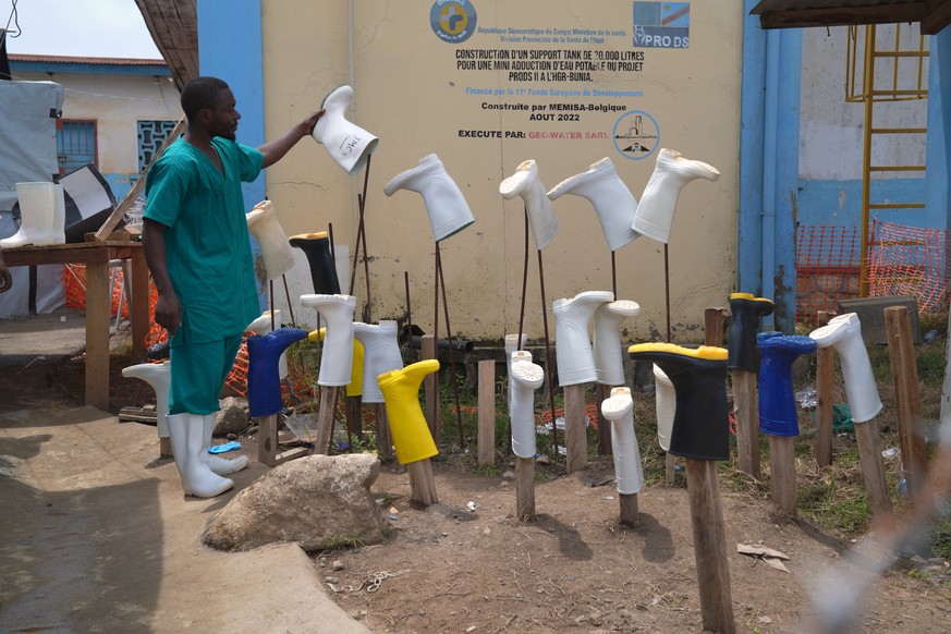 KEYPIX - A health worker dries boots that were washed to prevent the spread of the Ebola virus at the treatment centre in Bunia General Hospital in Ituri, eastern Congo, Tuesday, Aug. 11, 2026. (AP Ph ...