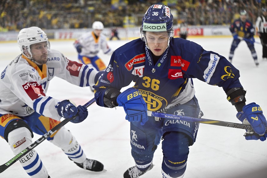 Der Davoser Simon Knak, rechts, gegen den Zuger Sven Leuenberger, im Eishockey-Qualifikationsspiel der National League (NL) zwischen dem HC Davos und dem EV Zug am Dienstag, 11. Februar 2025, in der z ...