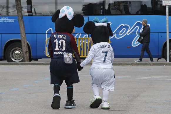 Two people dressed in Disney costumes, ply for tourist photos wearing shirts of Neymar and Ronaldo before a Round of 16, 1st leg Champions League soccer match between Real Madrid and Paris Saint Germa ...