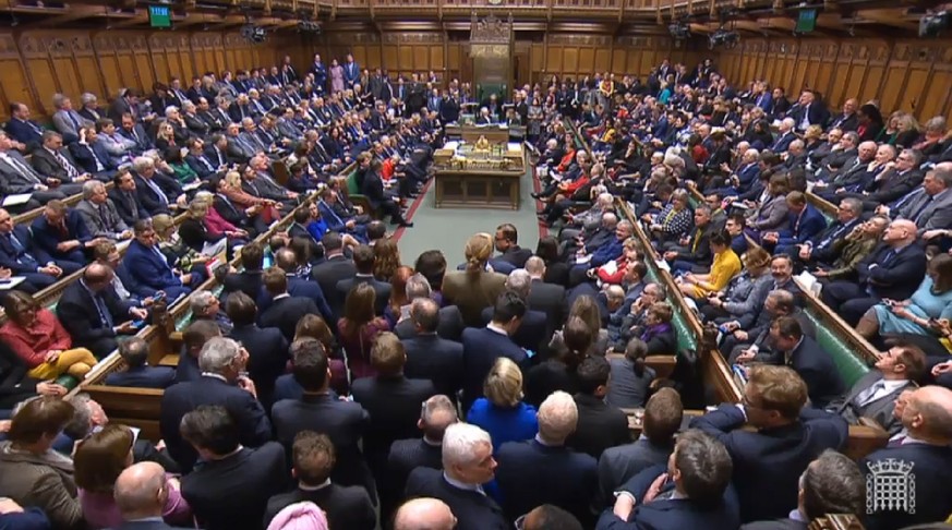 epa07432020 A grab from a handout video made available by the UK Parliamentary Recording Unit shows Members of Parliament after voting at the House of Commons parliament in London, Britain, 12 March 2 ...