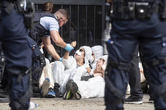 Polizisten fuehren die Klimaaktivisten der Organisation Clima Justice am Eingang der Schweizer Bank Credit Suisse ab, aufgenommen am Montag, 8. Juli 2019 auf dem Paradeplatz in Zuerich. (KEYSTONE/Enni ...