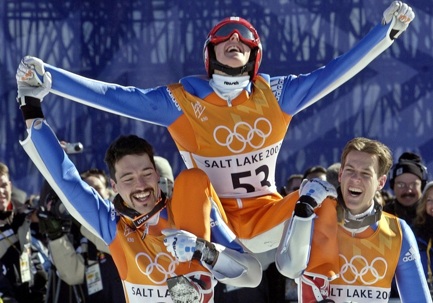 Simon Ammann of Switzerland, center, celebrates winning the gold medal with teammates Sylvain Freiholz, left, and Andreas Kuettel after the K90 Individual ski jump at the 2002 Salt Lake City Winter Ol ...