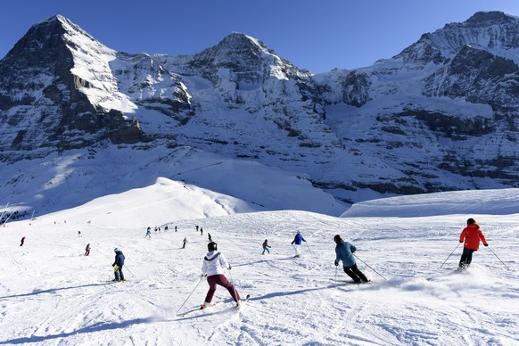 Skiers and Snowboarders enjoy the sunny weather and the snow with a beautiful view of Eiger, Moench and Jungfrau Mountain, from the Jungfrau Ski Area above Grindelwald, Switzerland, Monday, December 3 ...