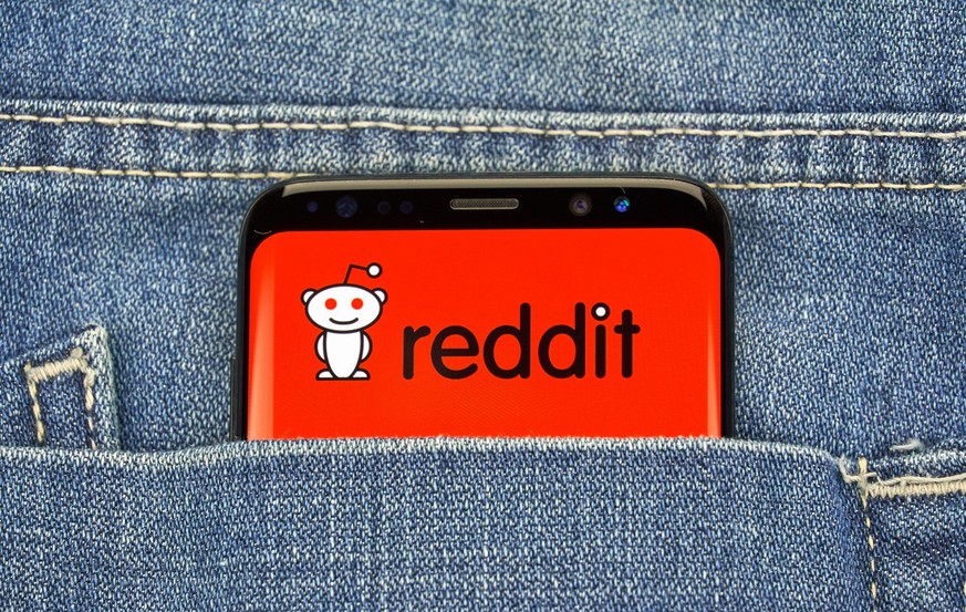 Smartphone mit Reddit-Logo in Hosentasche.