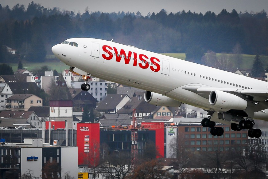 Ein Airbus 340-300 von Swiss Airlines startet auf der Piste 16, im Hintergrund die Gemeinde Ruemlang, am Mittwoch, den 29. November 2017 in Zuerich-Kloten. (KEYSTONE/Christian Merz)