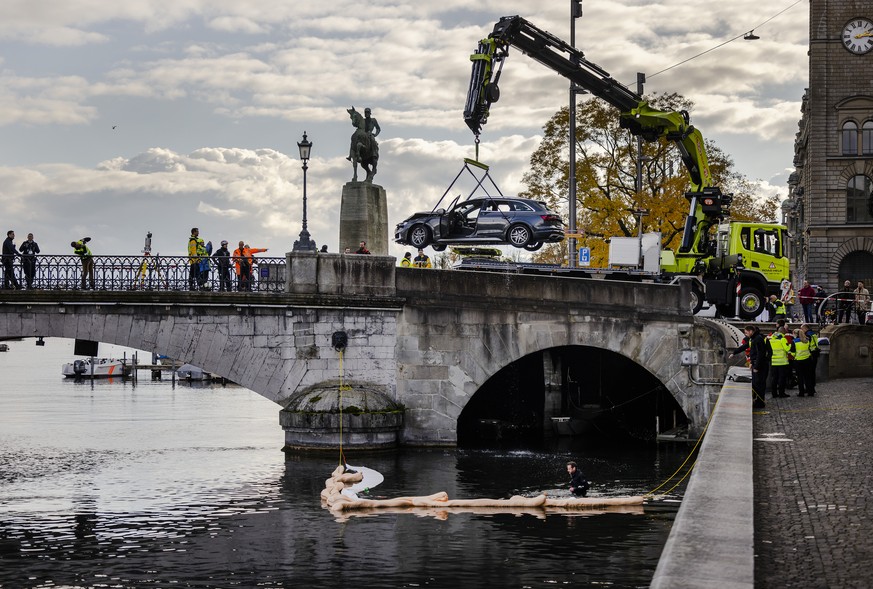 Rettungskraefte bergen einen Personenwagen neben der Muensterbruecke aus der Limmat, am Freitag, 5. November 2021 in Zuerich. (KEYSTONE/Michael Buholzer)..