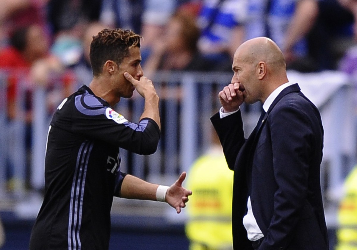Real Madrid's Cristiano Ronaldo speaks with Real Madrid's head coach Zinedine Zidane during a Spanish La Liga soccer match between Malaga and Real Madrid in Malaga, Spain, Sunday, May 21, 20 ...