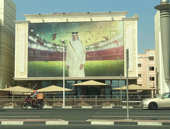 Ein Plakat des katarischen Staatsoberhauptes im Fussballstadion ziert ein Haus in Doha.