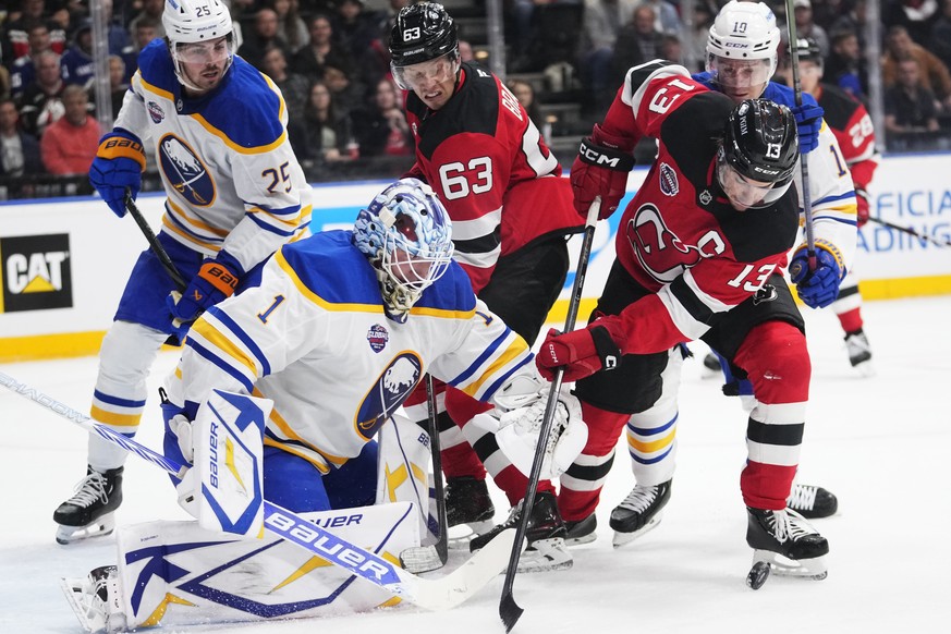 New Jersey Devils&#039; Nico Hischier, right, and Buffalo Sabres&#039; goaltender Ukko-Pekka Luukkonen battle for the puck during the NHL hockey game between Buffalo Sabres and New Jersey Devils, in P ...
