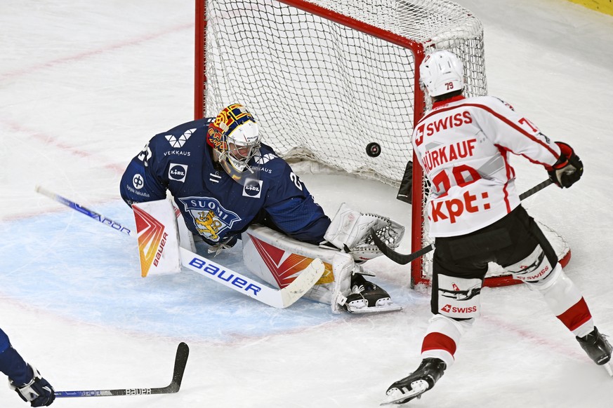 Swiss Calvin Thuerkauf scores the third goal for Switzerland aganist Finlands goalkeeper Harri Saeteri, left, during the Euro Hockey Tour - Swiss Ice Hockey Games .between Switzerland and Finland on S ...