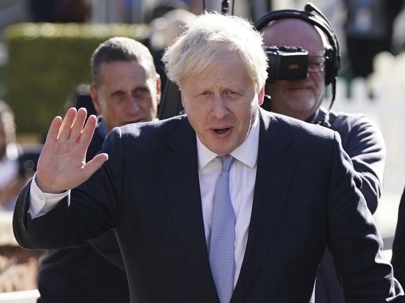 FILE - Britain&#039;s Prime Minister Boris Johnson waves to the media s he walks to the convention centre with his wife Carrie Johnson before he makes his keynote speech at the Conservative party conf ...