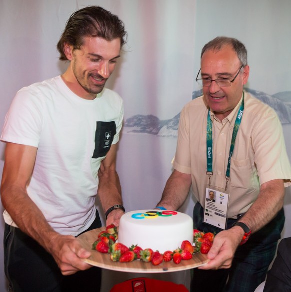 HANDOUT - Gold medal winner Fabian Cancellara of Switzerland, left, and Swiss Sport Minister Guy Parmelin, right, celebrate with a cake in the House of Switzerland at the Rio 2016 Summer Olympics in R ...