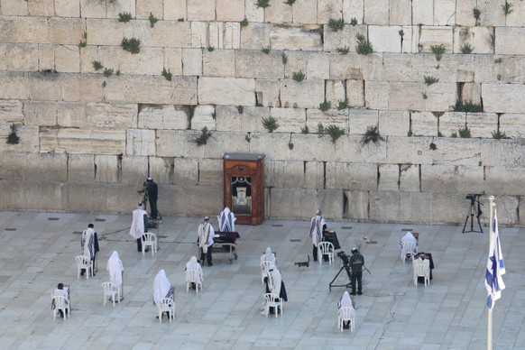 epaselect epa08358264 Orthodox Jews cover their heads with prayer shawls as they keep distance from each other while reciting the Priestly Blessing on the high holiday of Passover, in front of the Wes ...