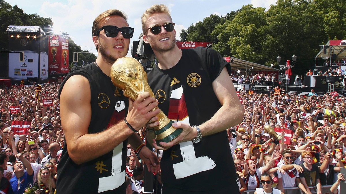 Germany's Mario Goetze (L) and Andre Schuerrle pose with the World Cup trophy during celebrations to mark the team's 2014 Brazil World Cup victory, at a 'fan mile' public viewing z ...