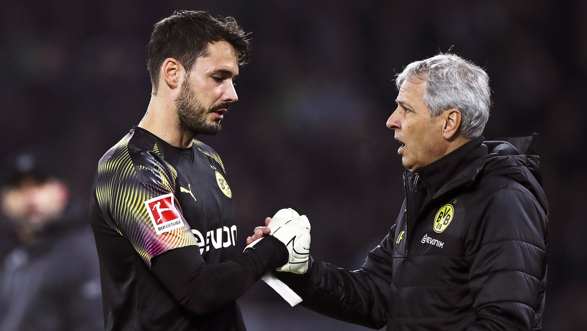 epa07934594 Dortmund's goalkeeper Roman Buerki (L) shakes hands with his coach Lucien Favre (R) as he leaves the pitch after picking up an injury during the German Bundesliga soccer match between ...