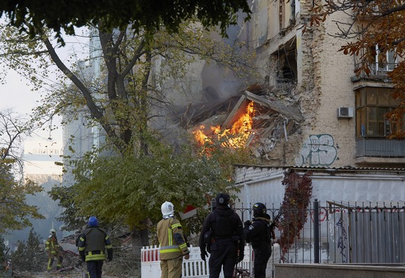 epa10248546 Rescuers and police officers work at the site of shelling in downtown Kyiv (Kiev), Ukraine, 17 October 2022, amid the Russian invasion. Several residential buildings were damaged as a resu ...