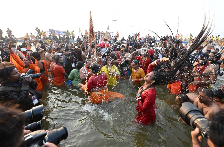 epa11871886 A handout photo made available by the Uttar Pradesh (UP) Information Department shows Hindu ascetic holy men and women taking part in a sacred bathing ritual, or 'Shahi Snan', on ...