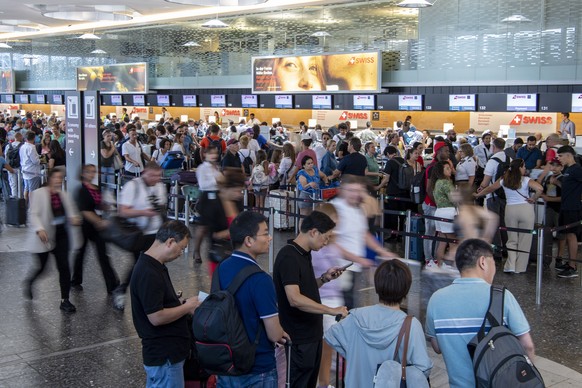 epa10747425 People line up in long queues as they wait in front of the check-in counters to be processed on their way to their holiday destinations, at the airport in Zurich, Switzerland, 15 July 2023 ...