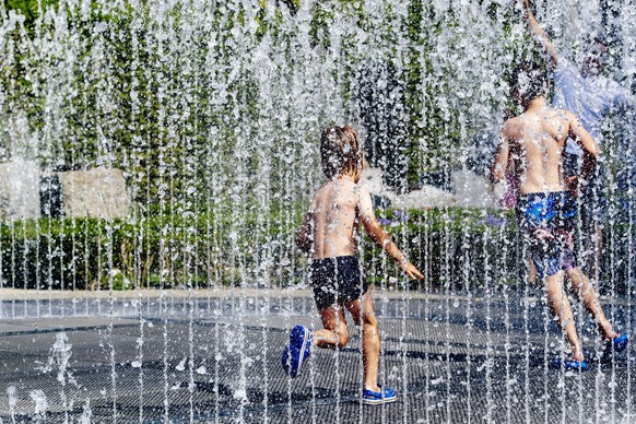 epa07739601 Children play in a fountain on the Museumplein, in Amsterdam, the Netherlands, 25 July 2019. The Royal Dutch Meteorology Institute (KNMI) has issued an official warning due to the warm wea ...