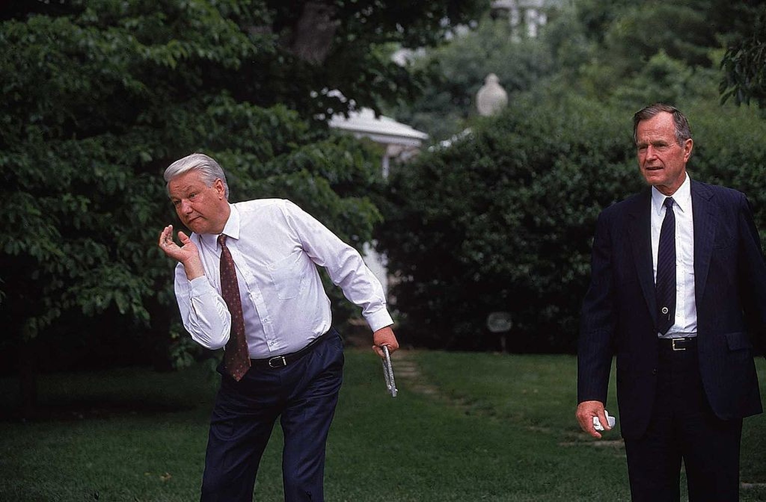 Pres. Bush (R) watching as Russian Pres. Boris Yeltsin, in town for summit mtg., pitches horseshoe during match at WH pit. (Photo by Dirck Halstead/Getty Images)