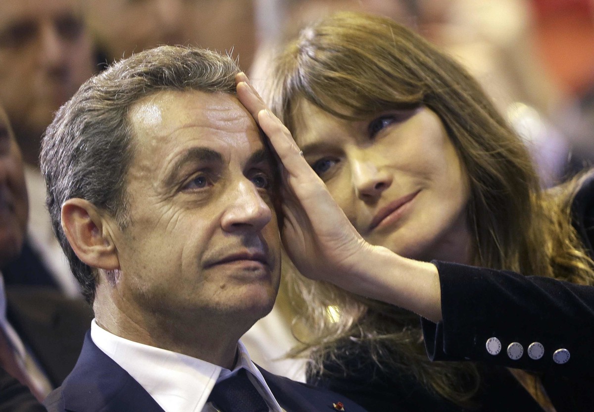 FILE - In this Thursday, Oct. 27, 2016 file picture, Carla Bruni-Sarkozy caresses the brow of her husband, the former French President and candidate for France's conservative presidential primary ...