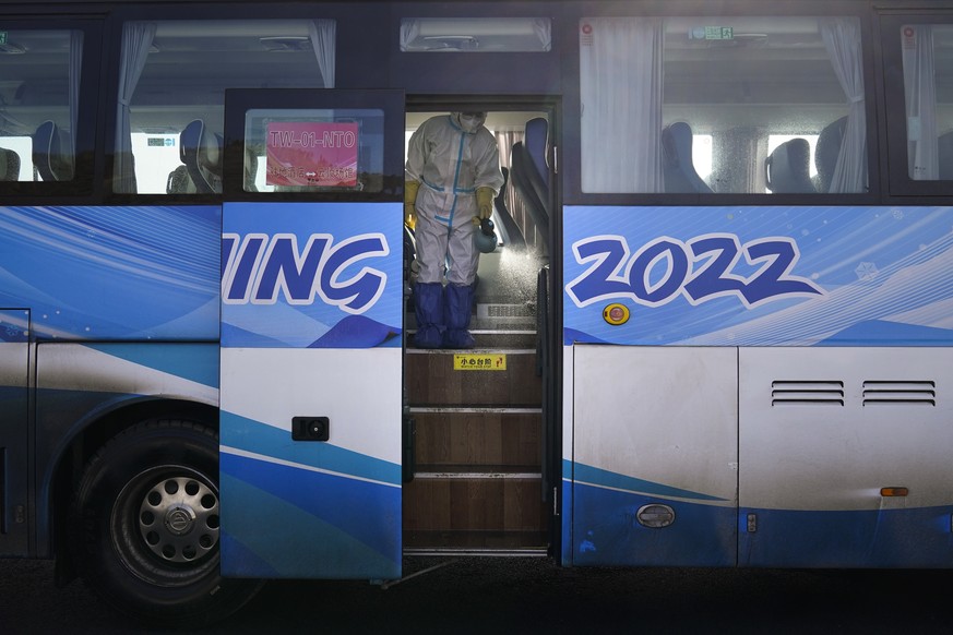 A worker in protective gear disinfects an Olympic shuttle bus ahead of the 2022 Winter Olympics, Jan. 30, 2022, in Zhangjiakou, China. (AP Photo/Jae C. Hong)