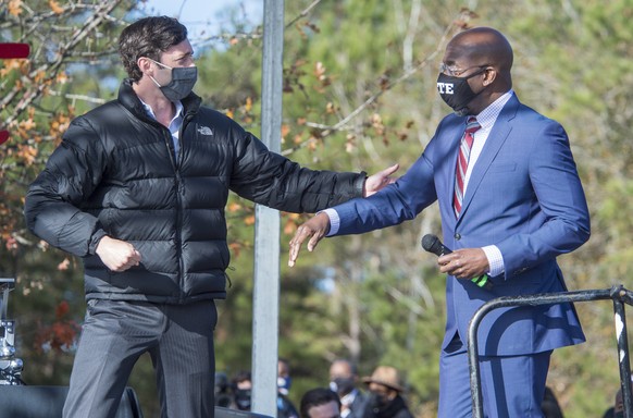 Jon Ossoff, left, and Raphael Warnock greet each other during a campaign rally in Augusta, Ga., Monday, Jan. 4, 2021. Democrats Ossoff and Warnock are challenging incumbent Republican Senators David P ...