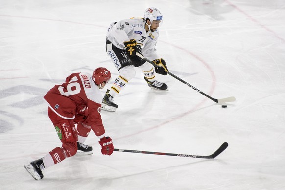 Le defenseur lausannois Joel Genazzi, gauche, lutte pour le puck avec l&#039;attaquant luganais Emerson Etem, droite, lors de la rencontre du championnat suisse de hockey sur glace de National League  ...