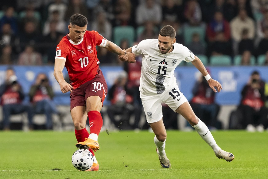 Switzerland&#039;s Granit Xhaka, left, and Slovenia&#039;s Danijel Sturm, right, fight for the ball during the FIFA World Cup 26 UEFA Qualifiers Group B match between Slovenia and Switzerland, at Stoz ...