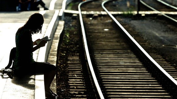 A women sits on the platform at the railwaystation of Lausanne, Switzerland, on wednesday, June 22, 2005. The entire network of the Swiss Federal Railways has shut down due to a power failure, leaving ...