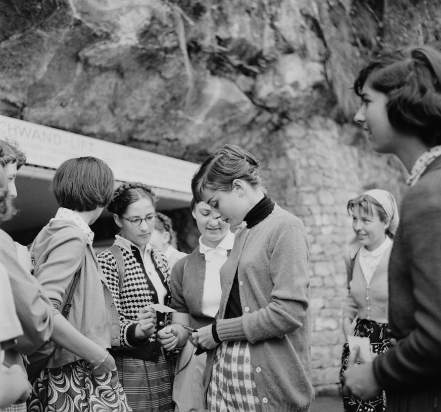 Belgian-born actress Audrey Hepburn (1929 - 1993) signs autographs for fans at the base of the Hammetschwand Lift on the Bürgenstock, Switzerland, circa 1955. (Photo by Graphic House/Archive Photos/Ge ...