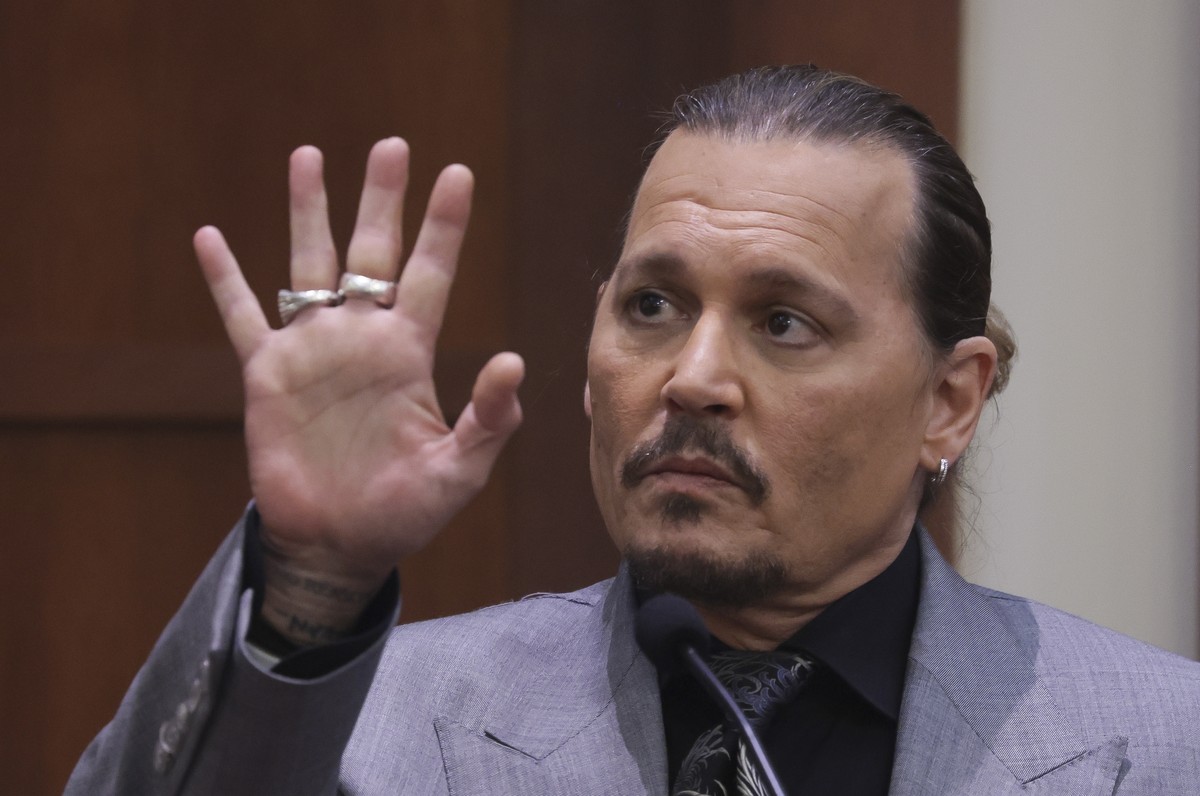 epa09899055 Actor Johnny Depp displays the middle finger of his hand, injured while he and his ex-wife Amber Heard were in Australia in 2015, as he testifies during his defamation trial against Heard  ...