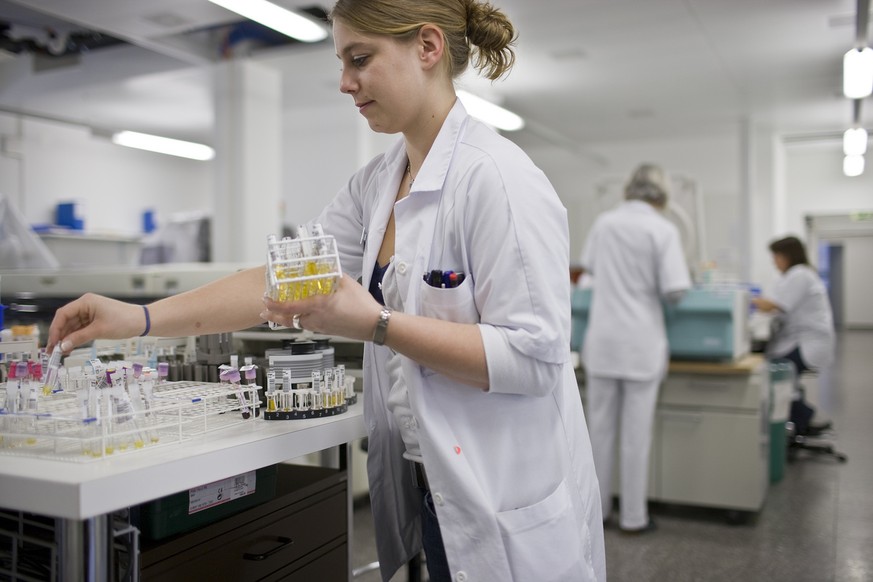 An employee of the medical laboratory Logolab Inc. at the hospital Sanitas in Kilchberg in the canton of Zurich, Switzerland, checks containers with samples, pictured on February 17, 2009. (KEYSTONE/G ...