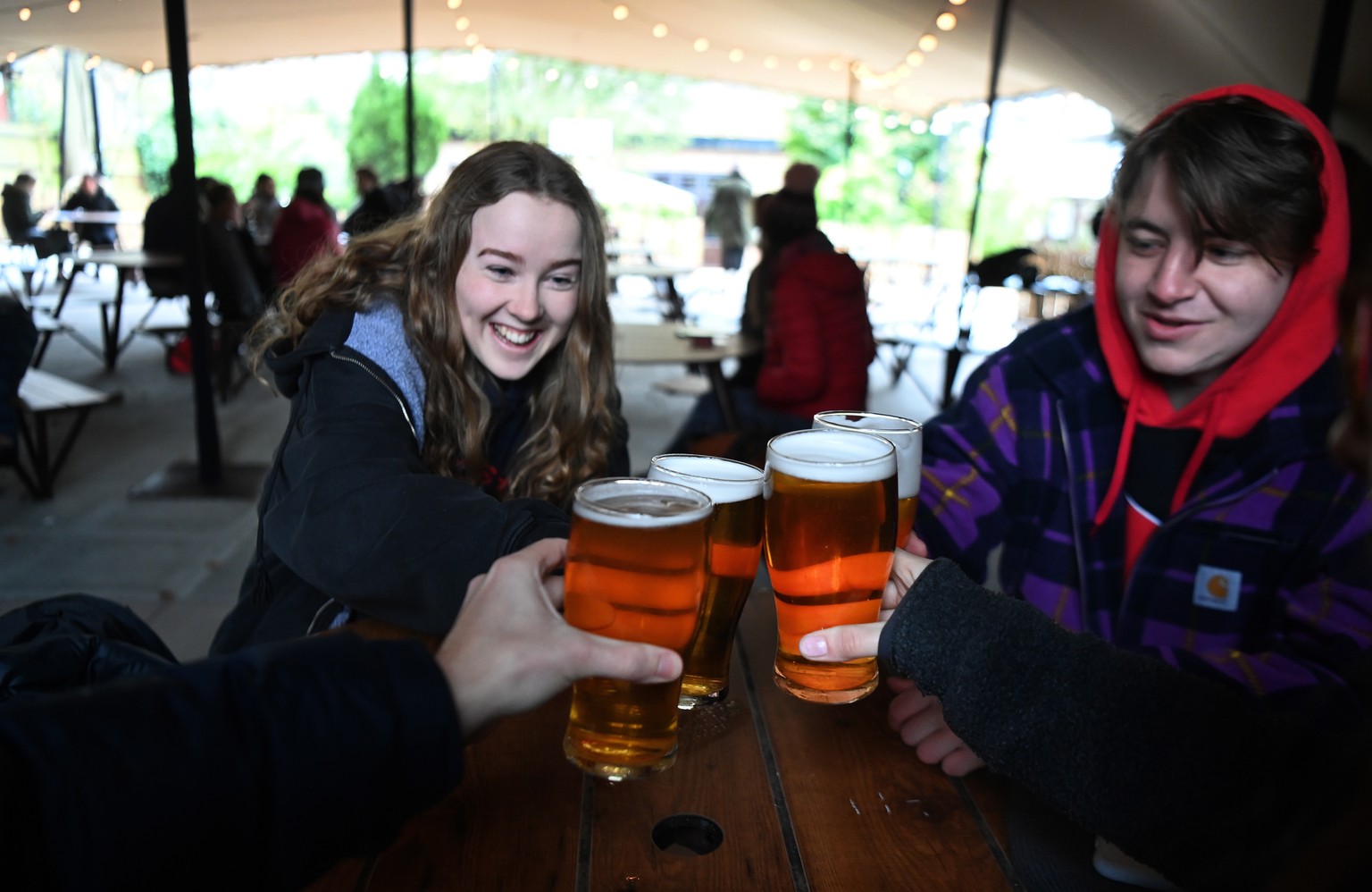 epa09130144 Young people enjoy a pint at the Fox on the Hill pub in South London, Britain, 12 April 2021. Britain has begun its second phase of unlocking after months of lockdown. Pubs, restaurants an ...