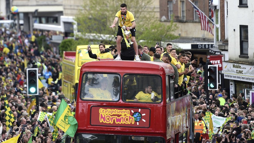 Norwich City's Grant Hanley stands with the trophy during a promotion parade, in Norwich City Centre, in Norwich, England, Monday May 6, 2019. Having already secured promotion to the Premier Leag ...