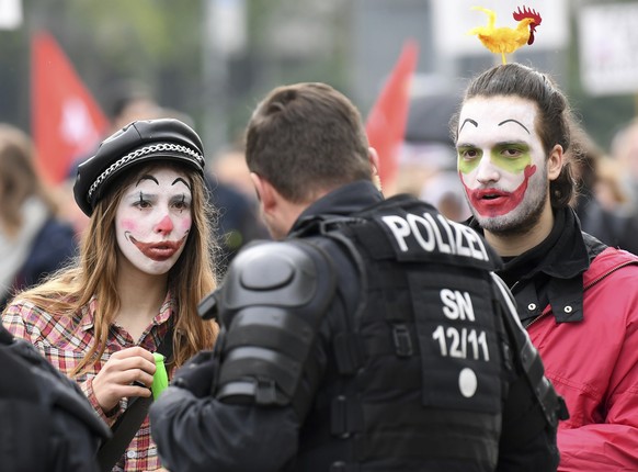 Protestors dressed as Clowns talk to police at a May Day demonstration against racism in Chemnitz, Germany, May 1, 2019. (Hendrik Schmidt/dpa via AP)