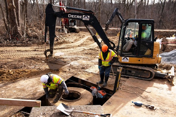 Workers build a cofferdam to stop the flow of raw sewage into the Potomac River after a massive sewage pipe rupture in Glen Echo, Md., Friday, Jan. 23, 2026. (AP Photo/Cliff Owen)
