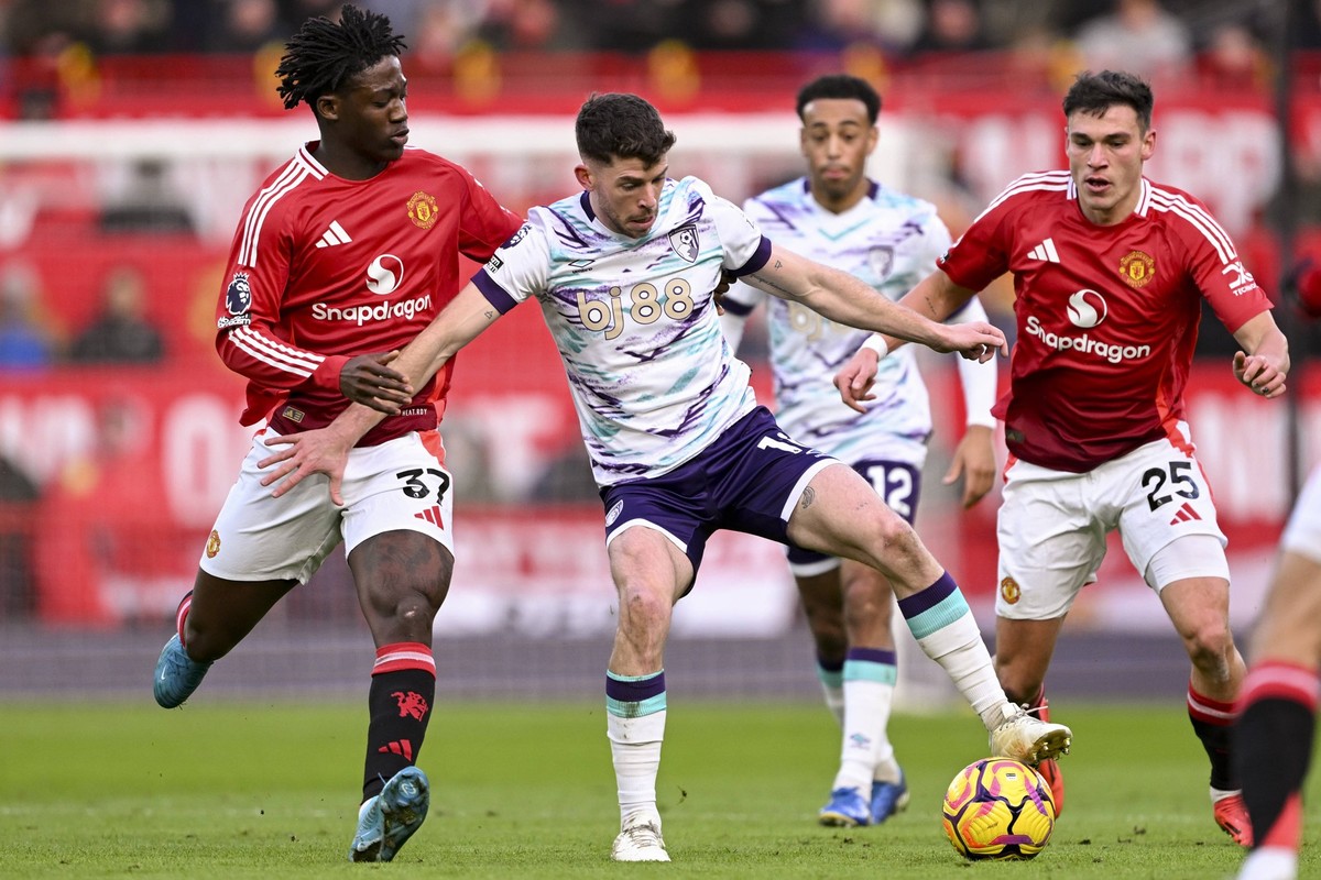 MANCHESTER, ENGLAND - DECEMBER 22: Ryan Christie of Bournemouth C plays against Kobbie Mainoo of Man. United L during the Premier League 2024/25 Matchweek 17 match between Manchester United, ManU FC a ...