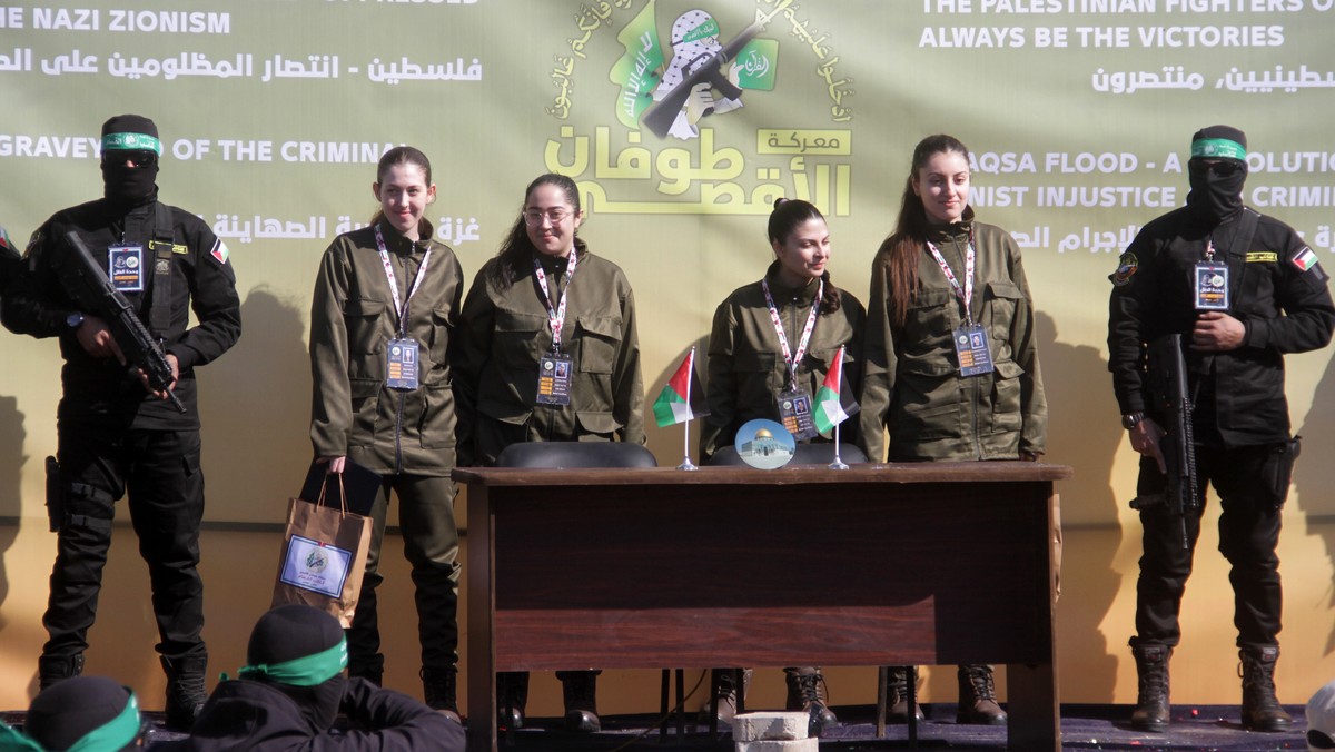 epaselect epa11851213 (L-R) Israeli hostages Naama Levy, Liri Albag, Daniella Gilboa and Karina Ariev stand on a stage before being delivered to the representative of the International Committee of th ...