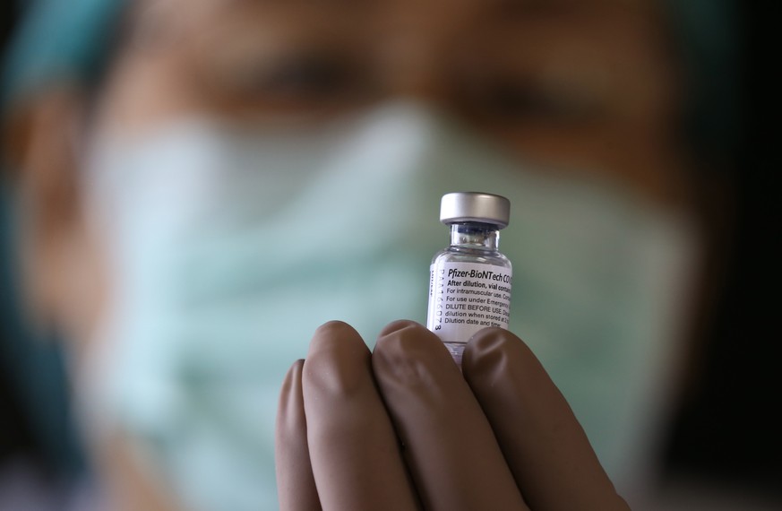 epa09406903 Thai medical official looks on the Pfizer COVID-19 vaccine as prepares for booster dose, at the Bangkok Metropolitan Administration General Hospital in Bangkok, Thailand, 09 August 2021. T ...