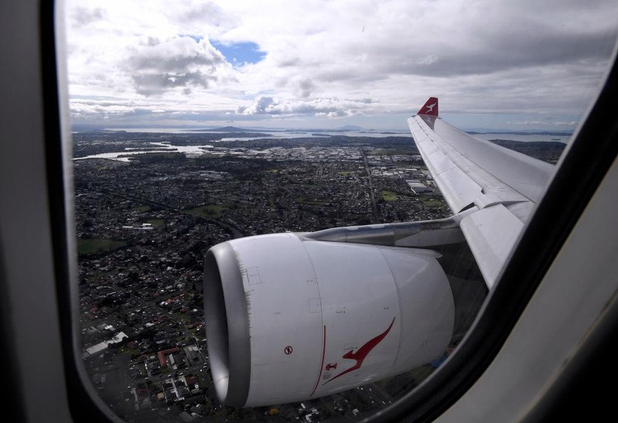 AUCKLAND, NEW ZEALAND - APRIL 19: The view from a window aboard QANTAS flight QF143 as it prepares to land at the Auckland Airport on April 19, 2021 in Auckland, New Zealand. The trans-Tasman travel b ...