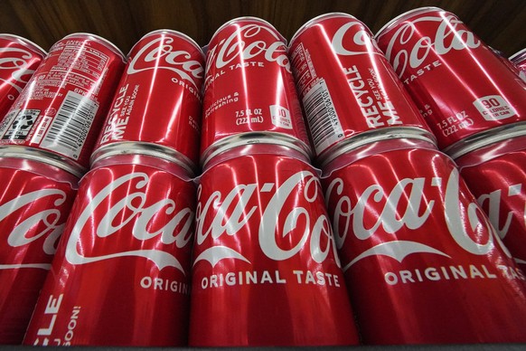 FILE - Cans of Coca-Cola are on display at a grocery market in Uniontown, Pa, April 24, 2022. (AP Photo/Gene J. Puskar, File)