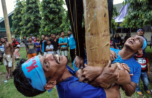 epa06703645 Indonesian laborers climb greased poles during a pole race to mark the May Day in Medan, North Sumatra, Indonesia, 01 May 2018. Labor Day, also known as International Workers&#039; Day or  ...