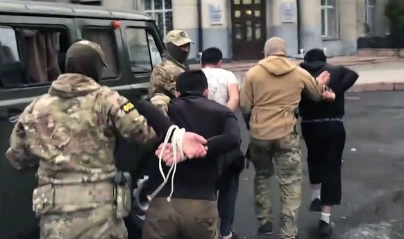 Russia Terrorists Detention 8254878 18.08.2022 In this handout video grab released by the Russian Federal Security Service FSB, FSB officers escort detained members of Katiba al-Tawhid wal-Jihad terro ...