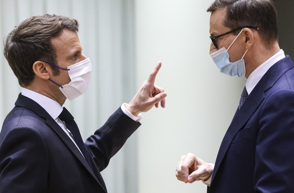 epa09765932 French President Emmanuel Macron and Polish Prime Minister Mateusz Morawiecki speak as they take part in a European Union leaders extraordinary summit to discuss the crisis between Russia  ...